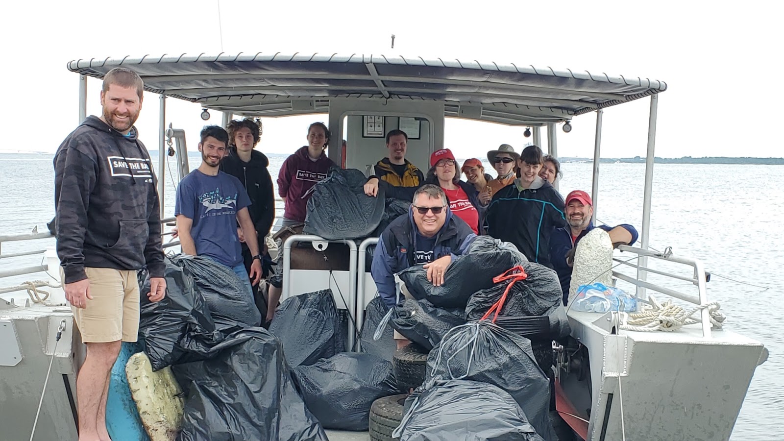 trash on the boat, surrounded by volunteers